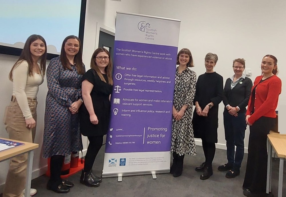 Speakers at the InvestHER event pose with the SWRC banner